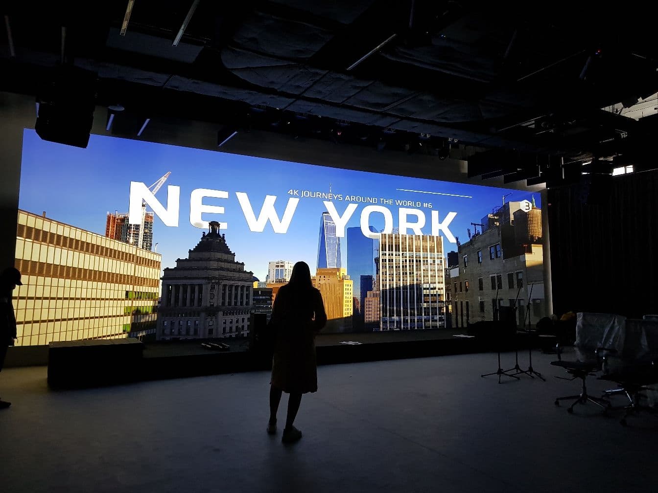 A person standing in front of a large screen, showcasing the projection wall powered by Screenberry at PMHUB