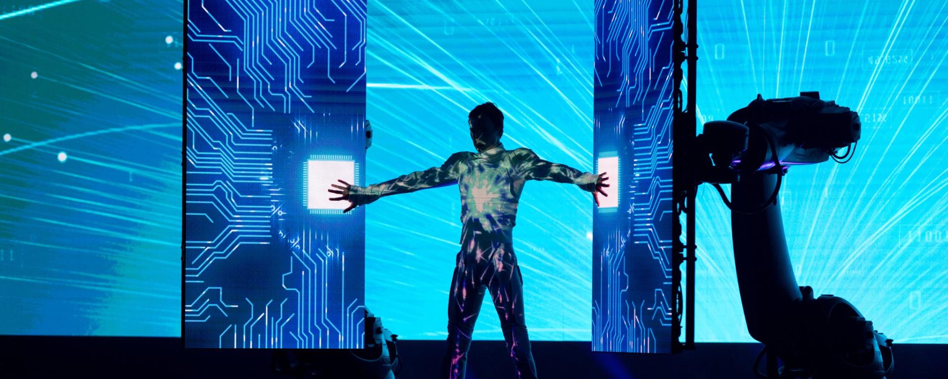 A performer interacts with LED screens during a multimedia performance at the Global AI Summit 2022