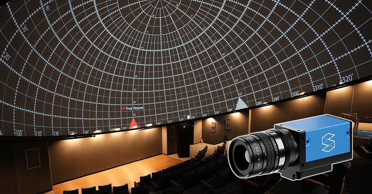 Picture of an industrial camera in front of a large dome screen, showcasing Screenberry's automatic camera-based projection calibration for quick and accurate alignment on curved surfaces