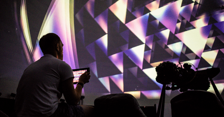 A man using a tablet computer to control the Meduza 360 real-time fulldome music visualizer
